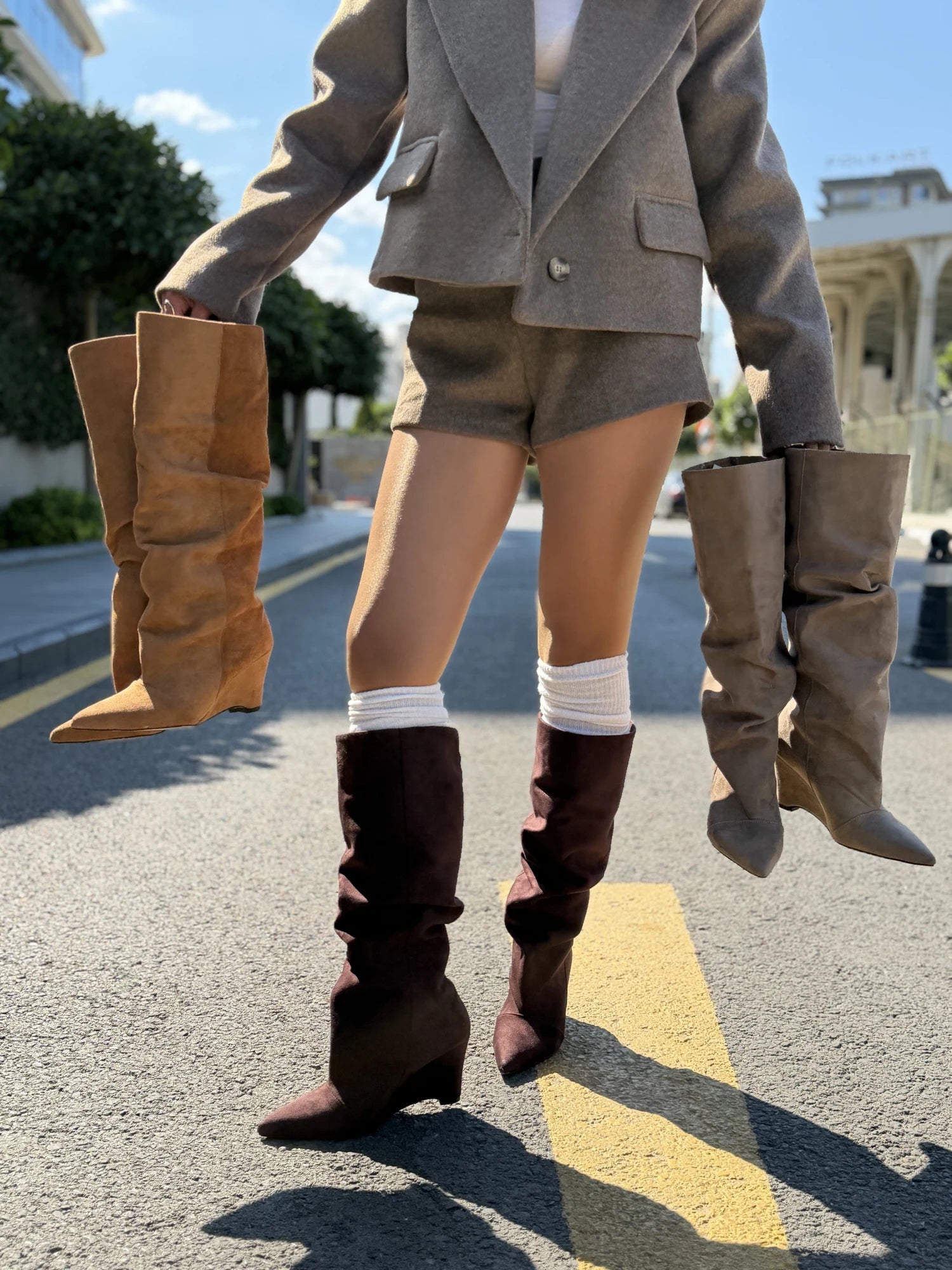 Tall boots in tan, burgundy and taupe on a city street