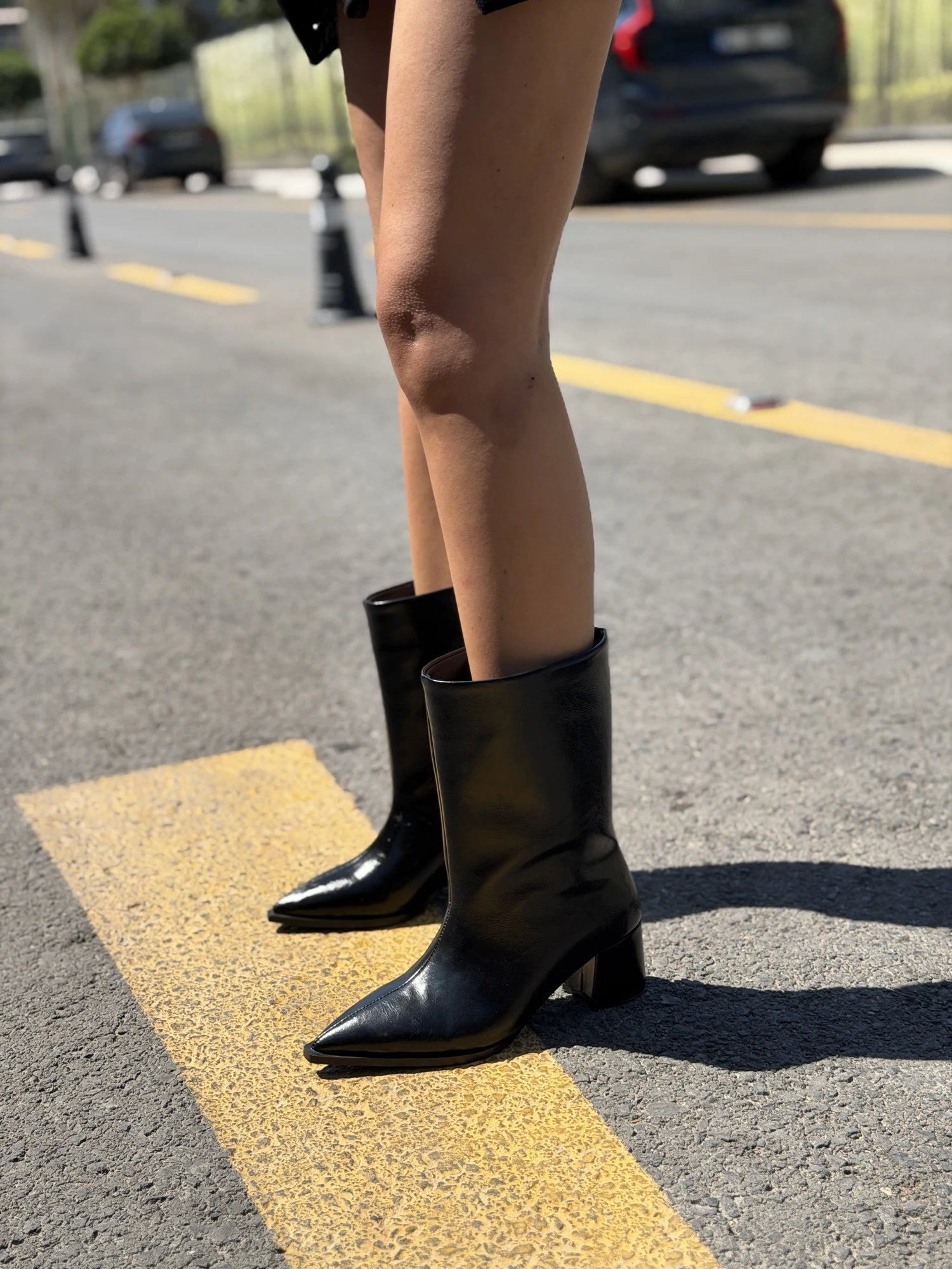 Black boots styled on a sunny city street